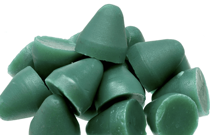 Green round-top finishing cones piled together on a white background